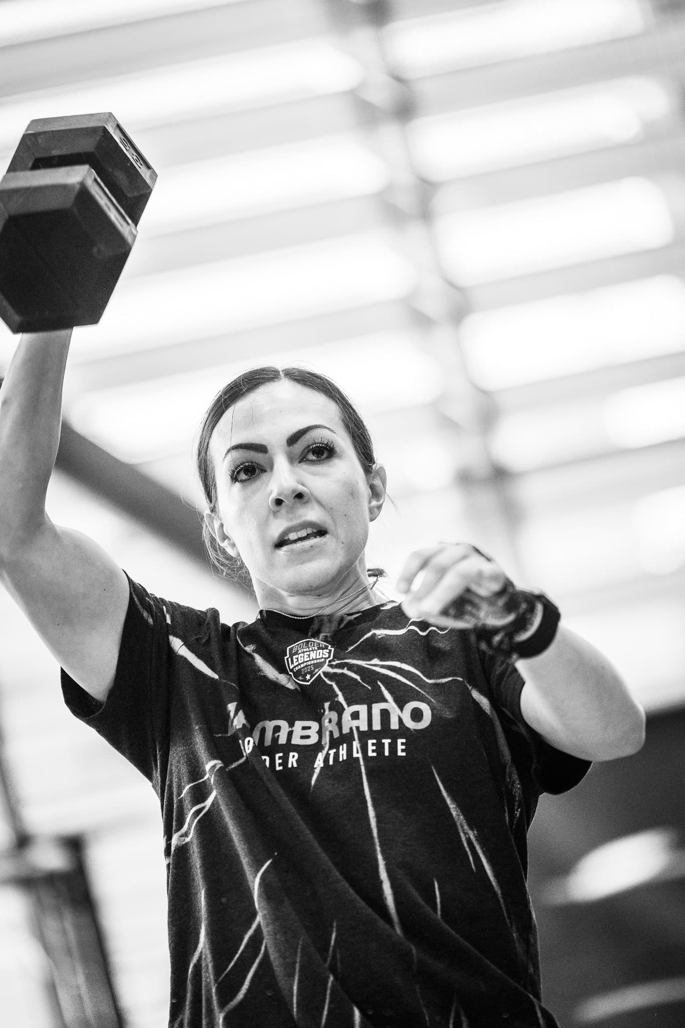 Bolder athlete pressing a dumbbell overhead