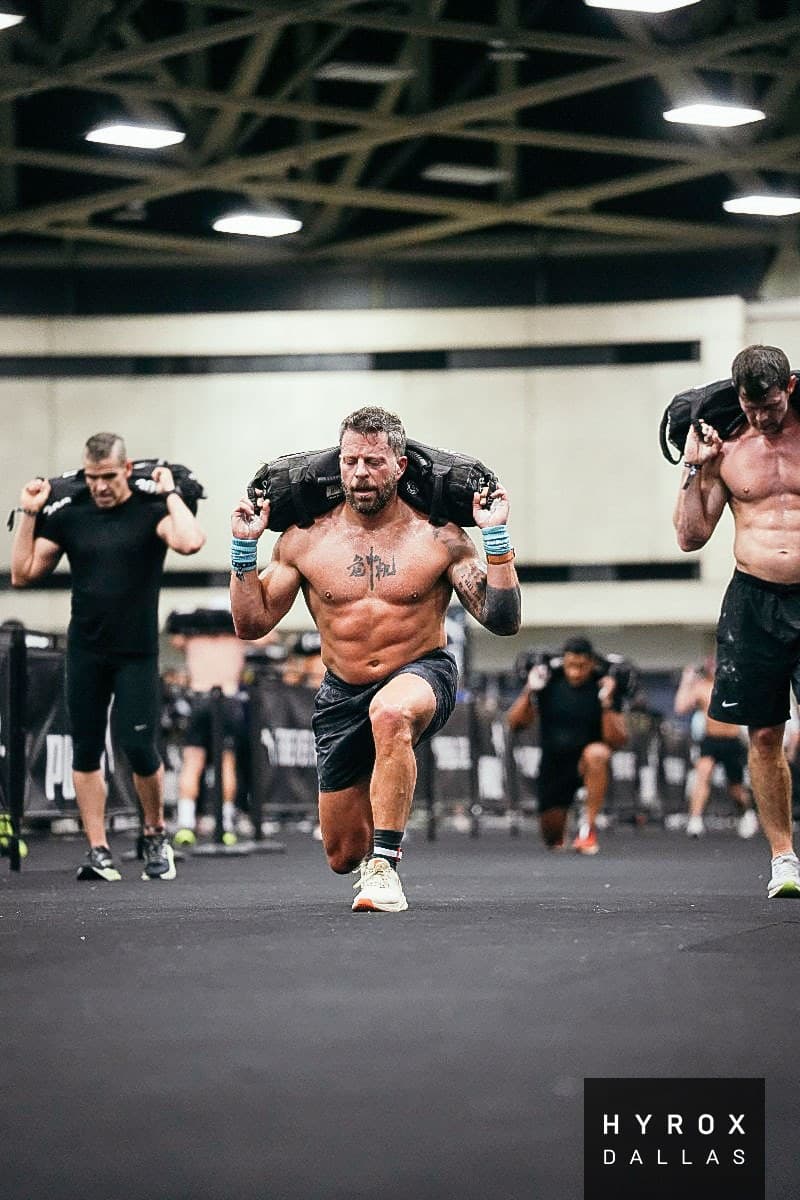 Jason Grubb doing sandbag lunges at HYROX Dallas