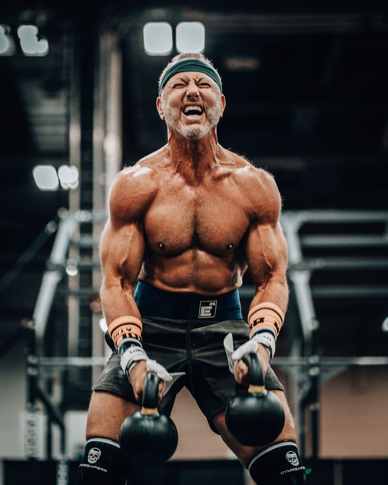 Athlete holding two kettlebells mid-workout