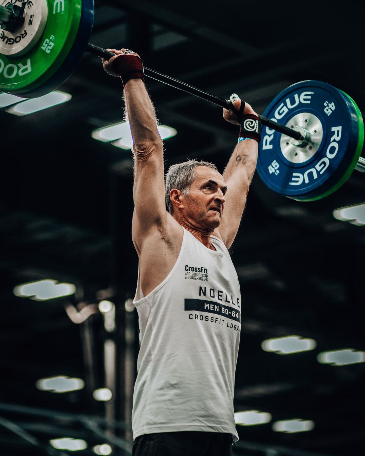 Masters athlete locking out a barbell overhead